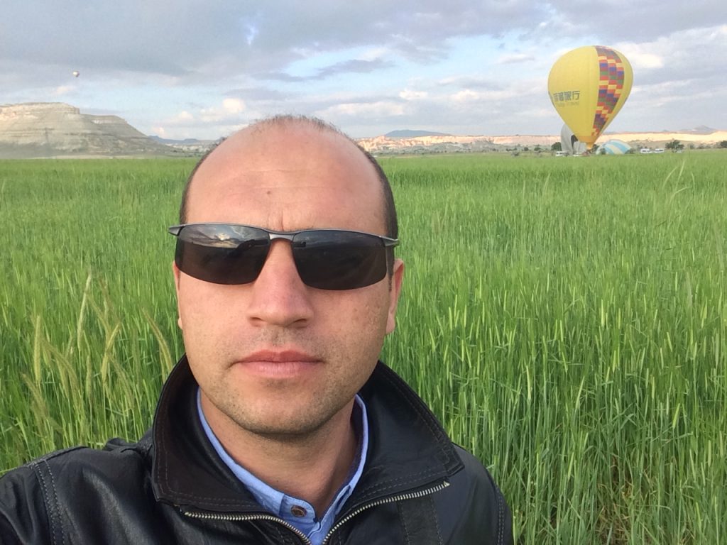 Turkish Private Driver Guide Mesut with Hot Air Balloons Rising in Cappadocia Turkey.